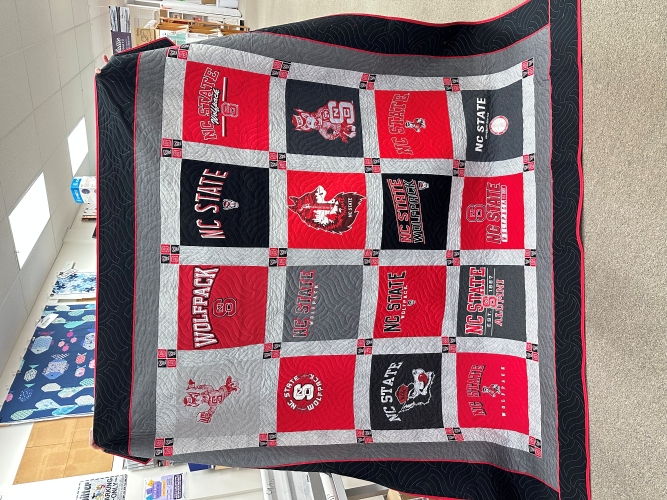 Quilt with NC State logos and colors displayed.